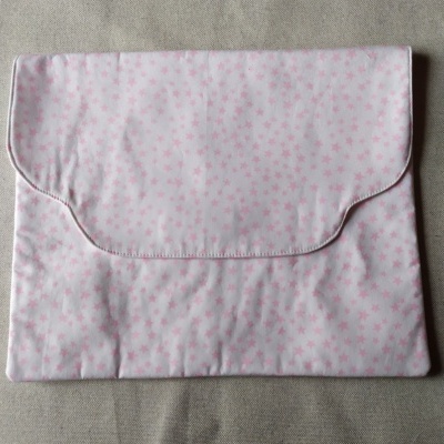 Envelope de tecido branco com estrelas cor-de-rosa sobre fundo cinzento