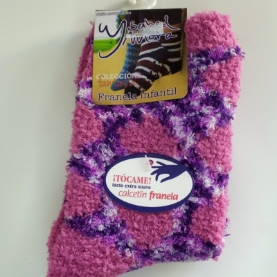 Meias infantis de flanela rosa, roxa e branca com etiqueta e gancho para pendurar.