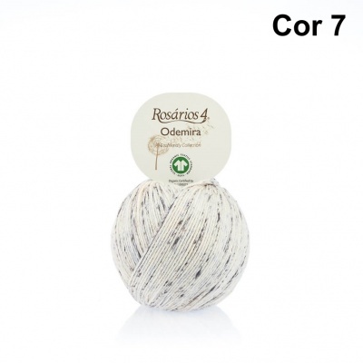 Novelo de fio de lã branco com manchas pretas e etiqueta redonda