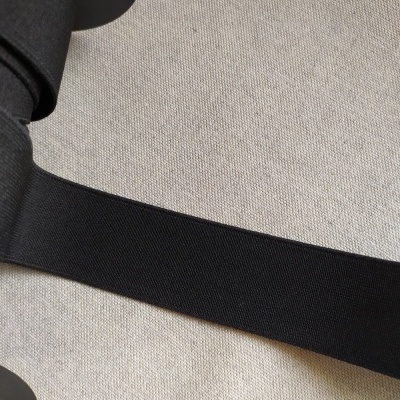 Fita elástica preta de 40 mm sobre tecido cinzento claro