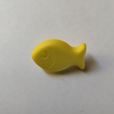 Peixe de plástico amarelo com olho e nadadeira sobre fundo branco