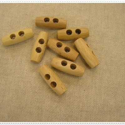 Botões de madeira clara com dois furos sobre tecido bege