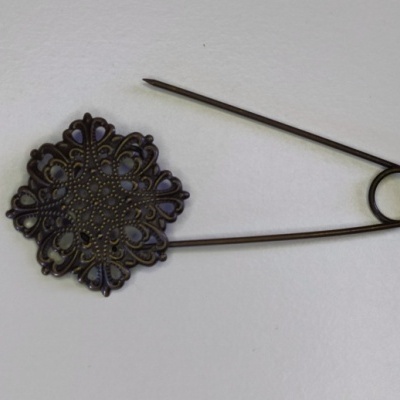 Alfinete de metal bronze com decoração rendilhada quadrada.