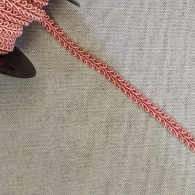 Fita decorativa rosa com padrão ondulado sobre tecido cinza