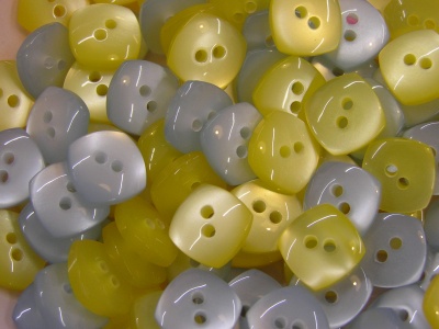 Botões quadrados amarelos, cinzentos e bege com dois orifícios