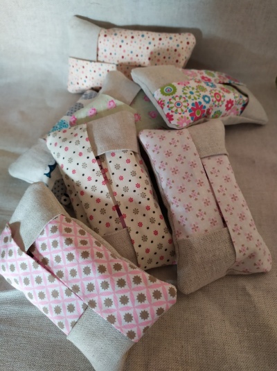 Saquinhos de tecido com padrões florais e geométricos em tons pastel com extremidades de linho bege