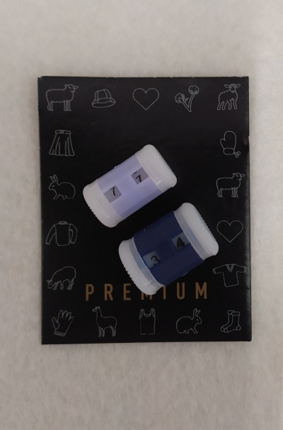 Dois contadores de plástico azul e lilás sobre superfície preta com ilustrações e texto