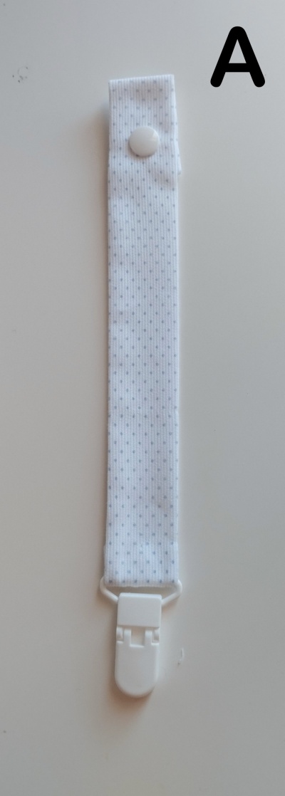 Tira branca com botão e clipe e letra A preta no fundo