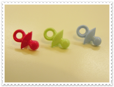 Três chuchas coloridas em linha sobre superfície amarela