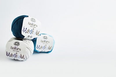 Três novelos de lã Natura Jazz Cotton nas cores azul escuro, branco e azul claro