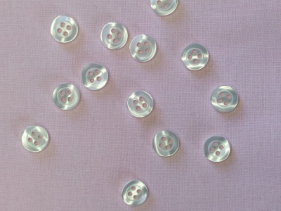 Botões brancos pequenos sobre tecido rosa