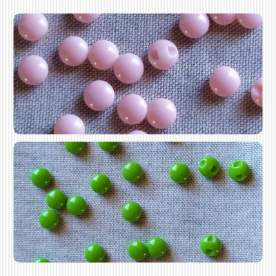 Contas redondas azuis claras e verdes sobre tecido cinzento