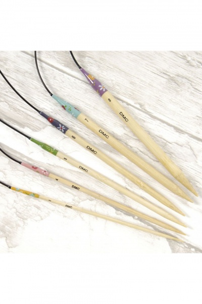 Set de agulhas de tricô coloridas em madeira com padrões florais e texto DMC