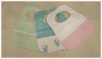 Três babetes de bebé verde, azul e branco com rosa, em tecido, com padrões e fecho de pressão