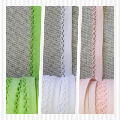 Três fitas rendadas coloridas verde, branco e rosa sobre fundo cinza