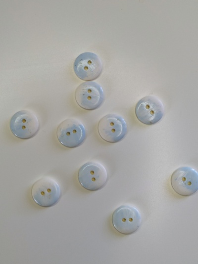 Dez botões brancos com dois furos sobre fundo branco