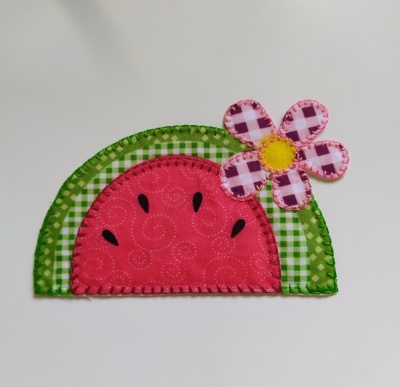 Aplicação em tecido em forma de melancia com flor rosa