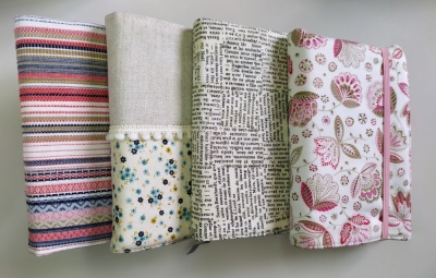 Quatro capas coloridas e com padrões variados para cadernos ou agendas.