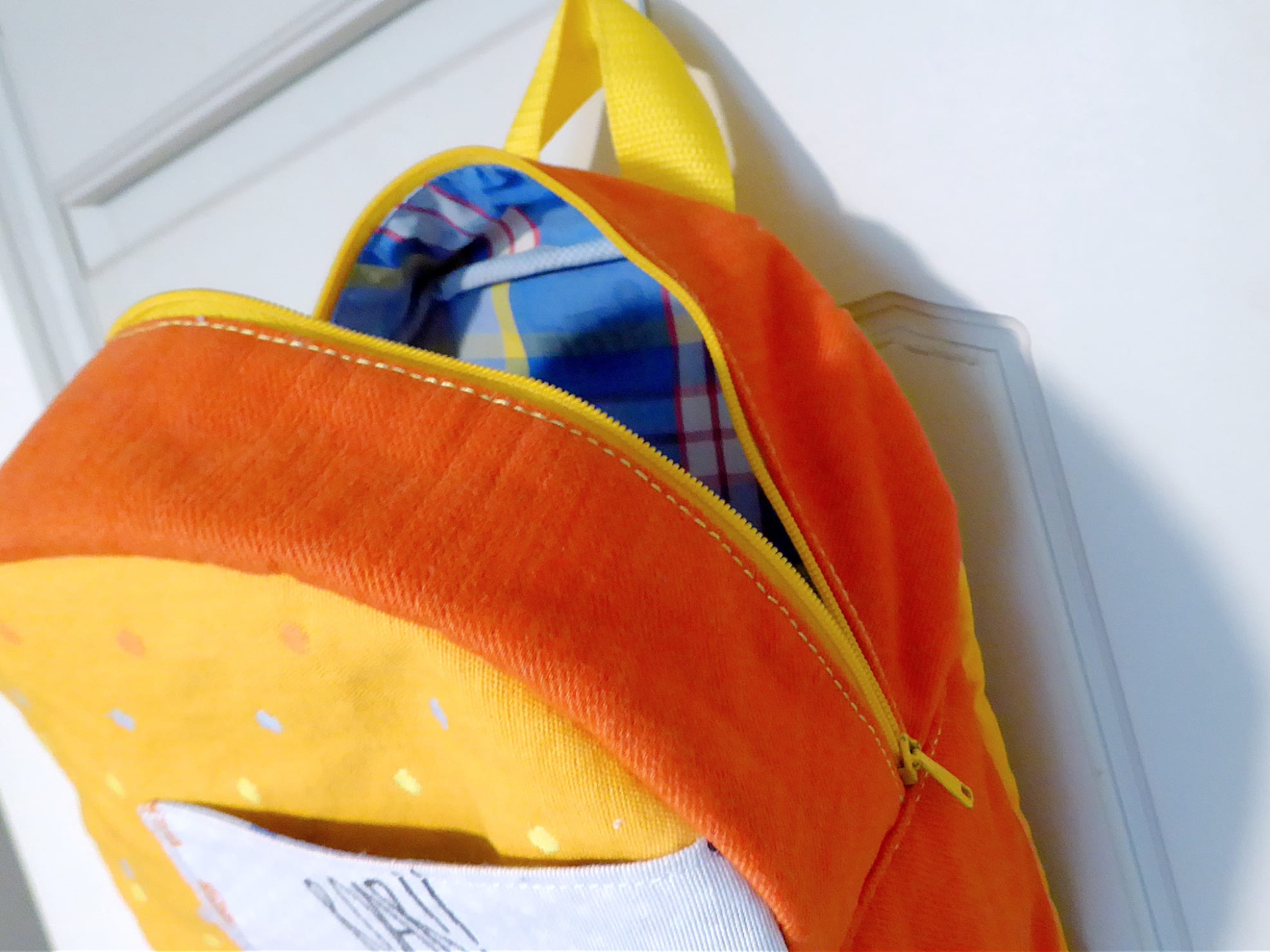 Mochila Pequena Mochila de pelúcia laranja e amarela com alça amarela pendurada