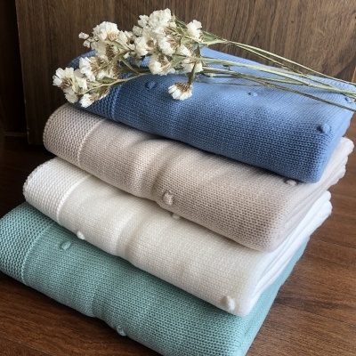 Mantinhas de malha coloridas empilhadas com flores secas em cima