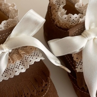 Sapatinhos de bebé castanhos com renda branca e fitas de cetim