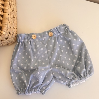 Calções de bebé azuis com estrelas brancas e botões de madeira