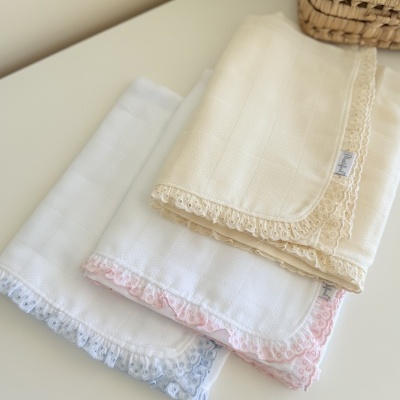 Três panos com bordas rendadas coloridas sobre uma superfície branca