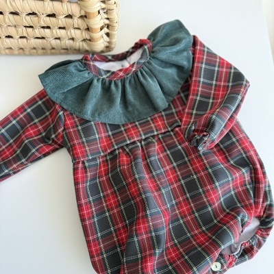 Roupa de bebé xadrez com gola verde em tecido de veludo e cesta de verga