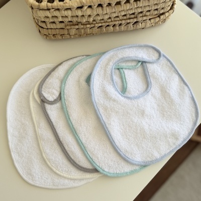 Conjunto de cinco babetes de tecido felpudo coloridos em tons neutros