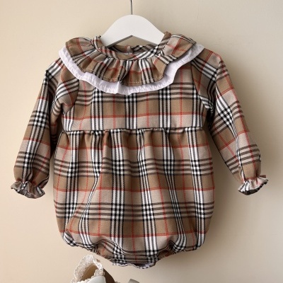 Body infantil xadrez com gola babada branca numa cabideira
