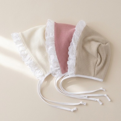 Três bonés de bebé em tecido waffle com renda branca e fitas para amarrar