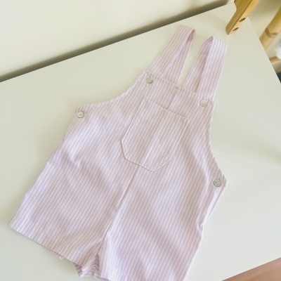 Macacão curto infantil cor-de-rosa com riscas brancas e bolso frontal