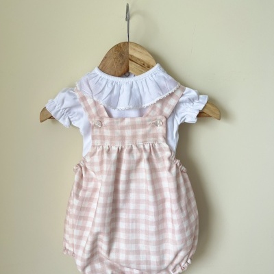 Macacão bebé xadrez rosa e branco com camiseta branca pendurado