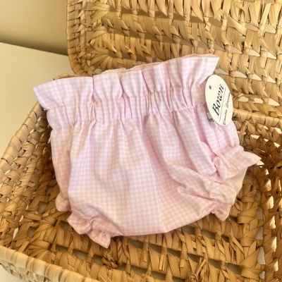 Calcinha rosa com padrão quadriculado numa cesta de palha