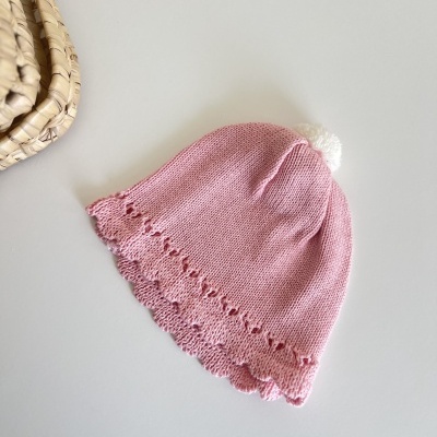 Gorro de malha rosa com pompom branco e borda decorativa