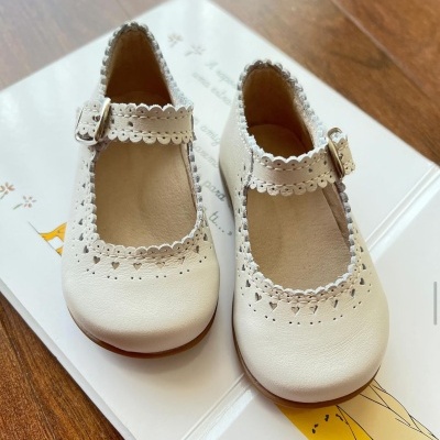 Sapatos infantis brancos de pele com detalhes decorativos