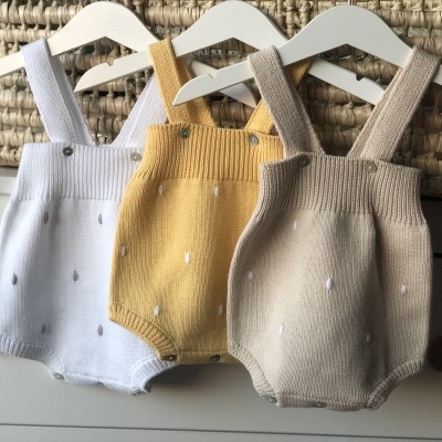 Três macacões de bebé de malha com alças nas cores branco, amarelo mostarda e bege