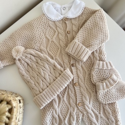 Conjunto de bebé bege em malha com macacão, gorro com pompom e botins