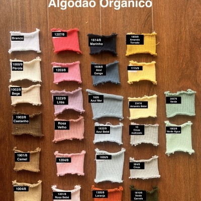 Amostras coloridas de tecido de algodão orgânico com etiquetas numéricas sobre superfície de madeira