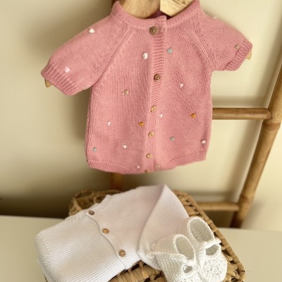 Conjunto de bebé com camisola rosa, camisola branca e sapatinhos de crochê