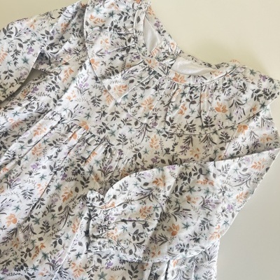 Vestido infantil branco com padrão floral e gola babado