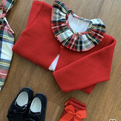 Conjunto de roupa de bebé com camisola vermelha, body com gola xadrez, meias vermelhas e sapatos pretos