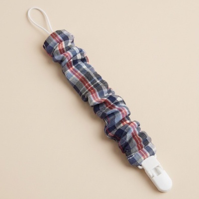 Suporte xadrez azul com clip branco e laço elástico.