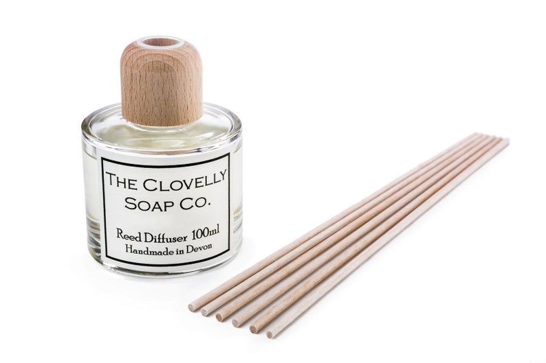 Frasco de vidro com difusor de varetas e seis varetas de madeira clara