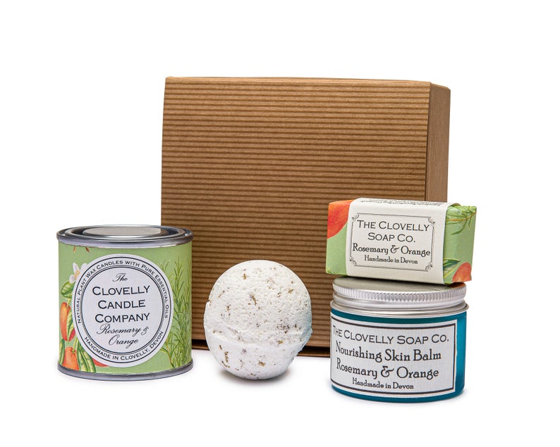 Pack presente com vela, bola de banho, sabonete e bálsamo para pele, apresentados sobre caixa de cartão