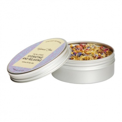 Embalagem metálica redonda com flores secas coloridas e etiqueta na tampa