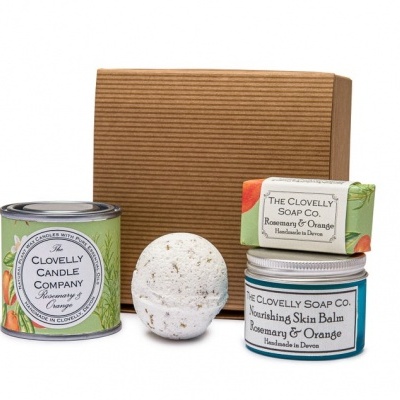 Pack presente com vela, bola de banho, sabonete e bálsamo para pele, apresentados sobre caixa de cartão