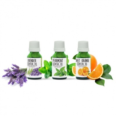 Três frascos verdes de óleos essenciais com ramos e frutas correspondentes