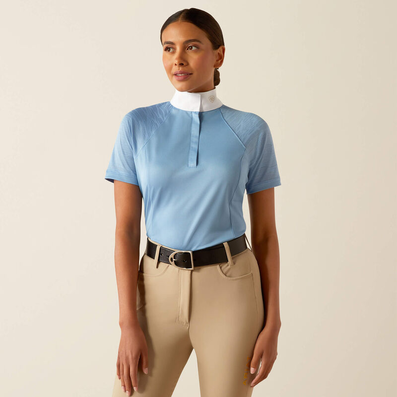 Pólo de Concurso ARIAT Aptos Vent 2.0 Mulher a vestir camisa azul clara de equitação com gola branca e calças bege