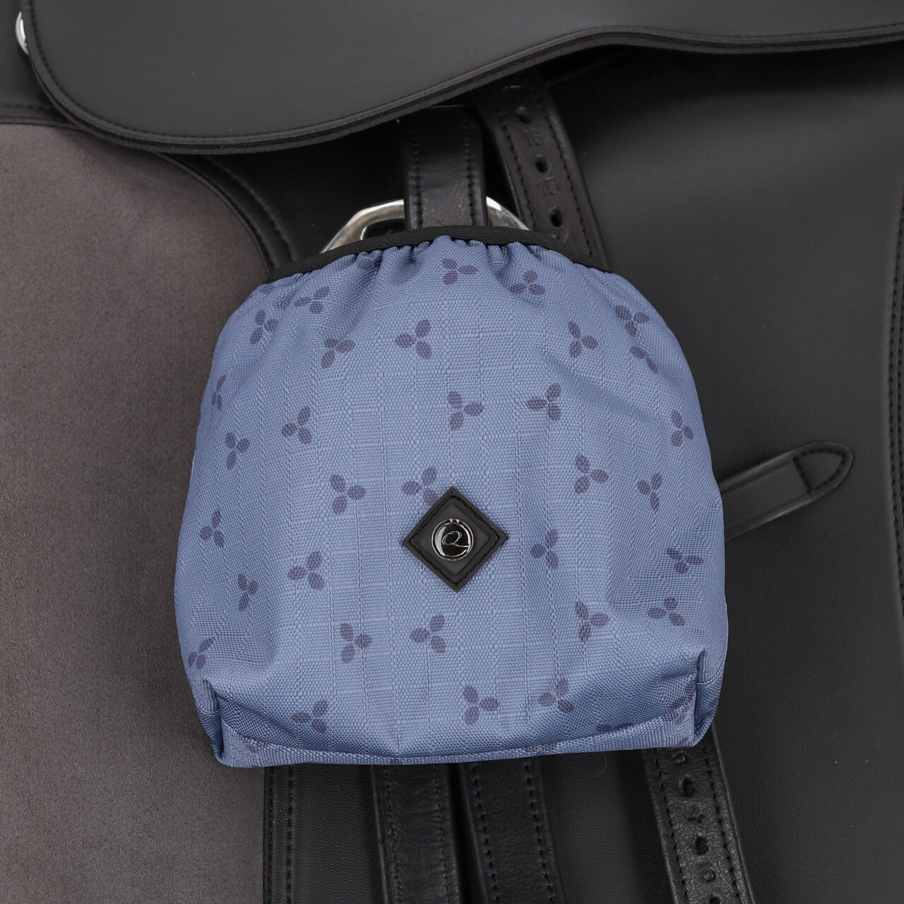 Capa p/ Estribos QHP 'Collection S26' Saco azul claro com padrão de triângulos escuros numa sela de cavalo preta